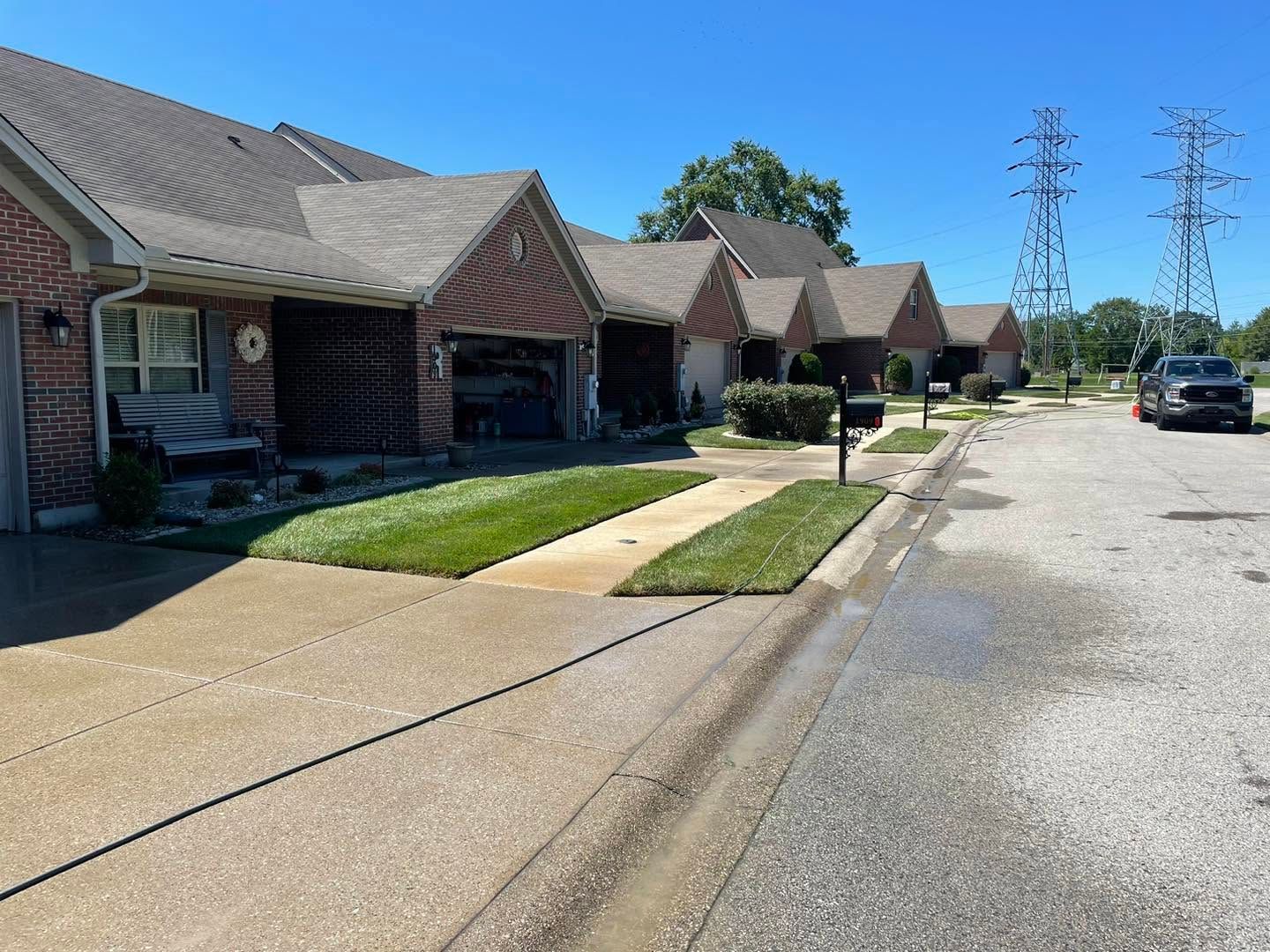 Row of brick townhouses along a quiet street under a clear blue sky