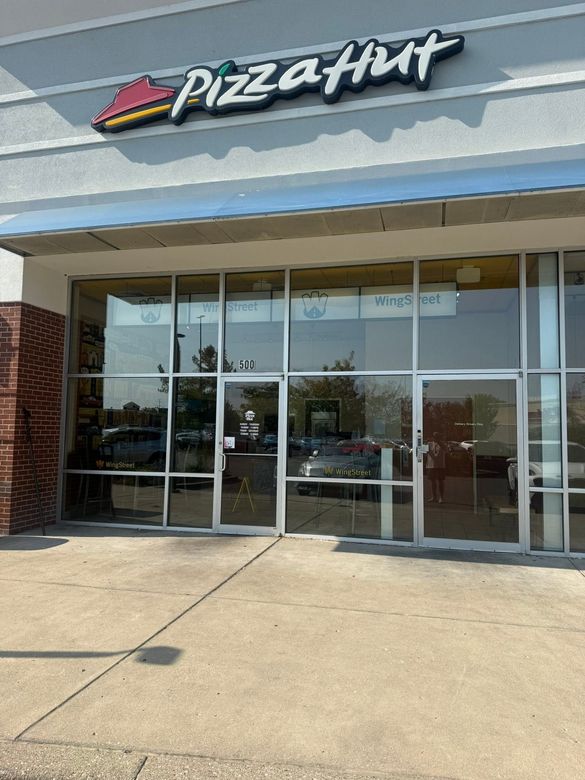 Pizza Hut storefront with glass entrance and red-and-white sign above the doors