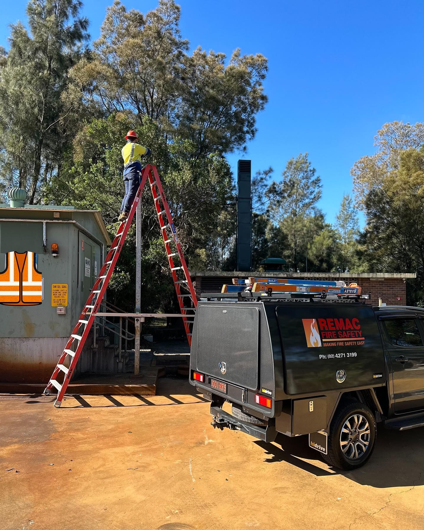 A man is standing on a ladder next to a truck. A man is standing on a ladder next to a truck.