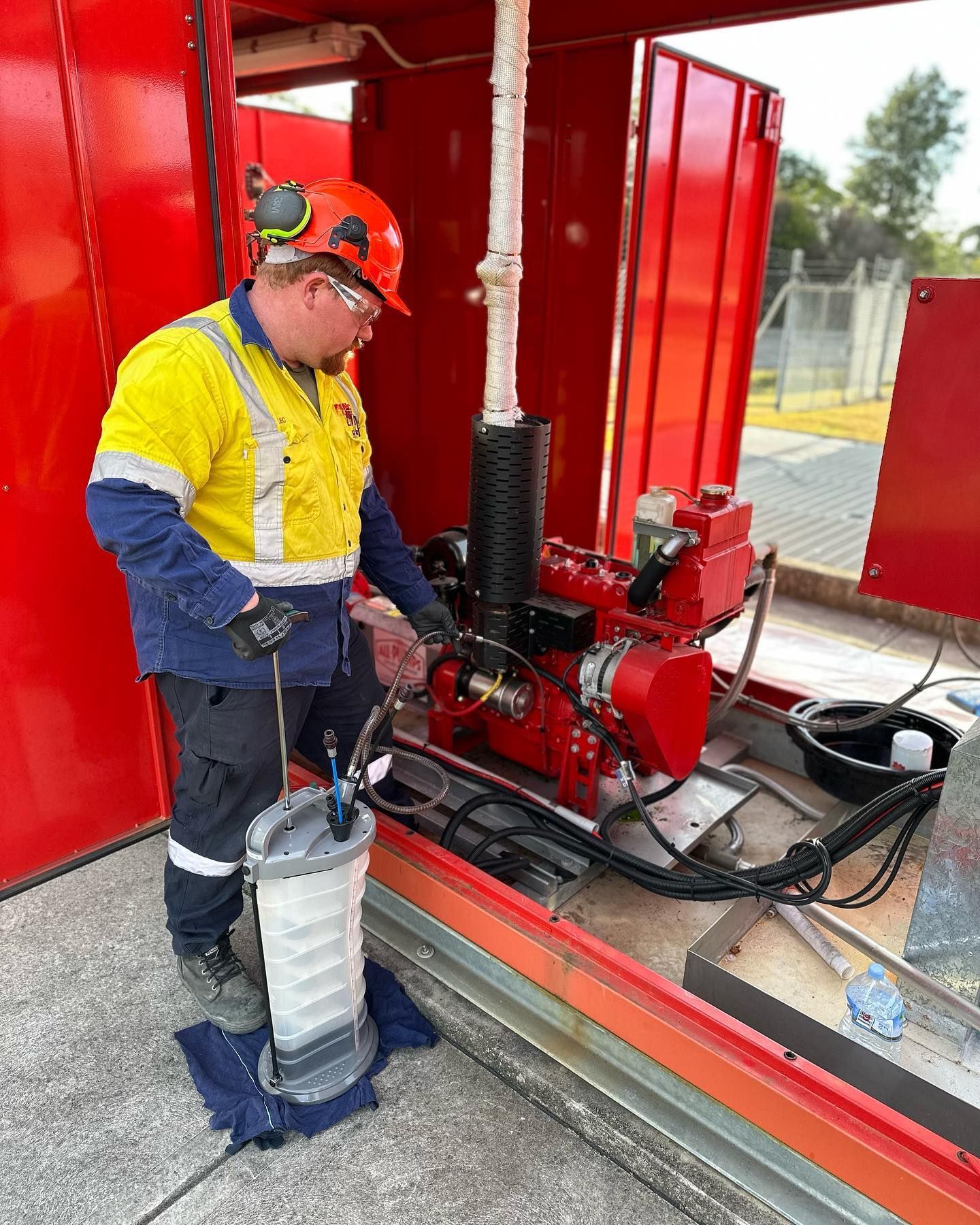 A man in a hard hat is working on a machine. A man in a hard hat is working on a machine.