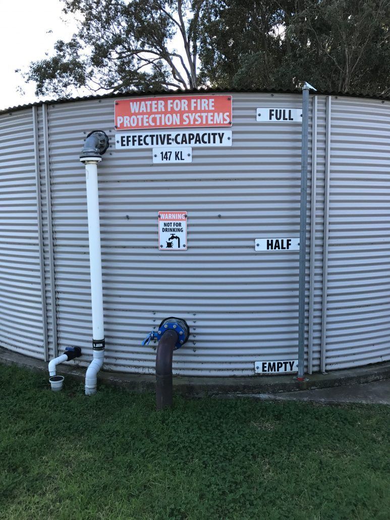 A large metal tank with a sign on it that says `` water for fire protection systems ''.