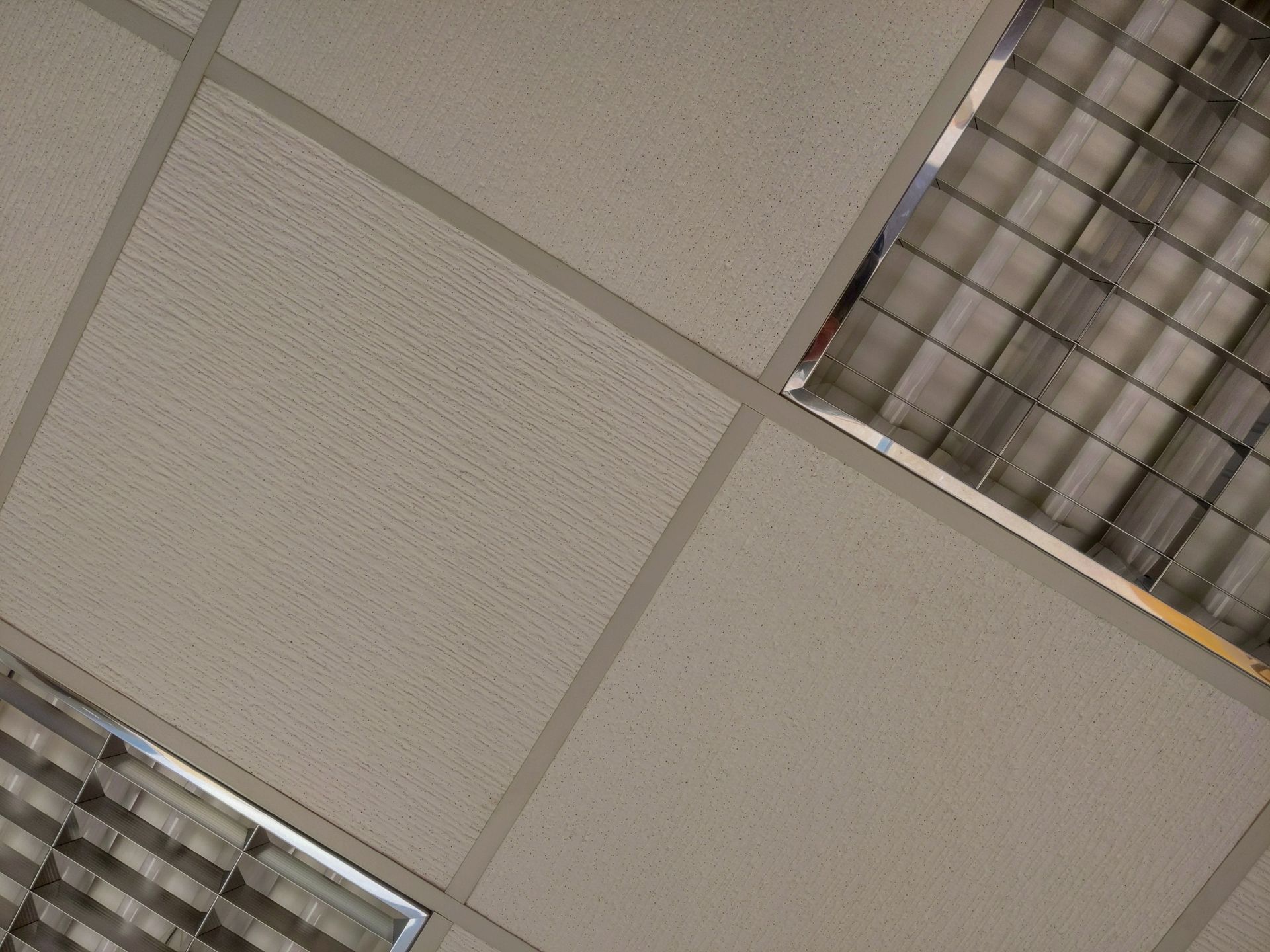 Modern drop ceiling with square panels and integrated linear LED lights.