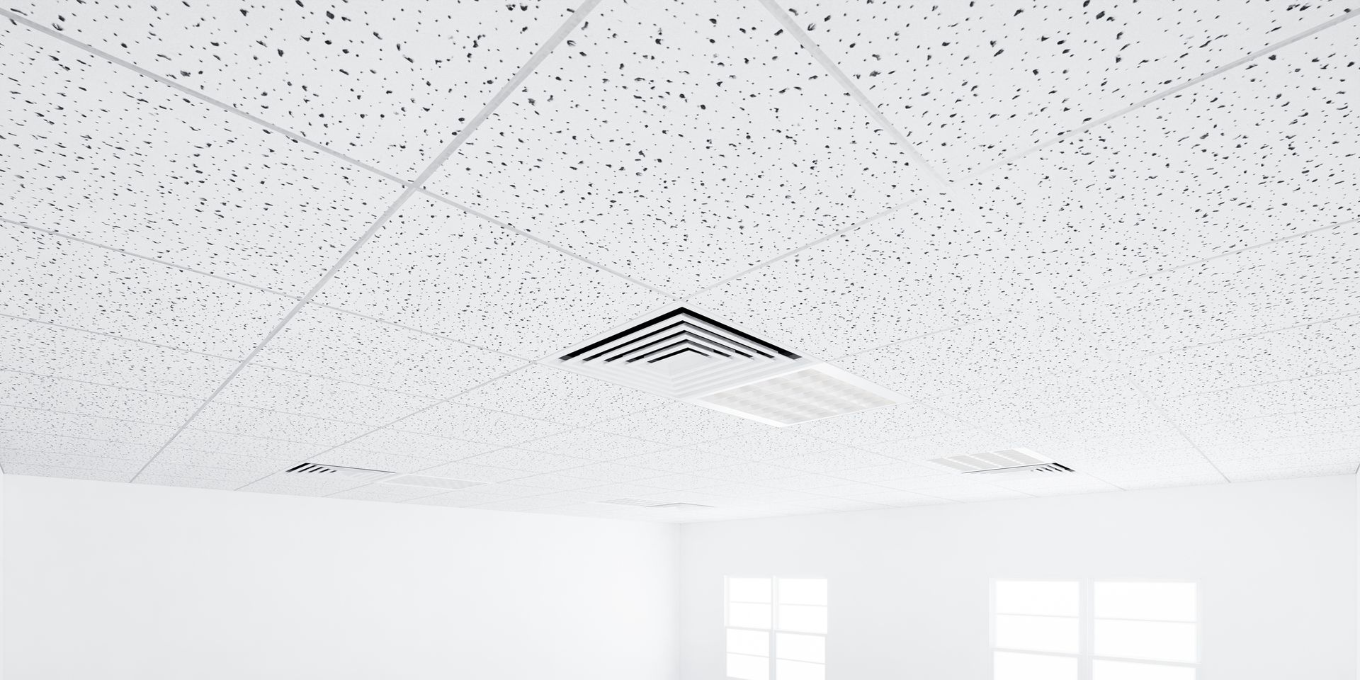 A white ceiling with a textured surface, including a black ventilation grill and grid lines, over a white room.