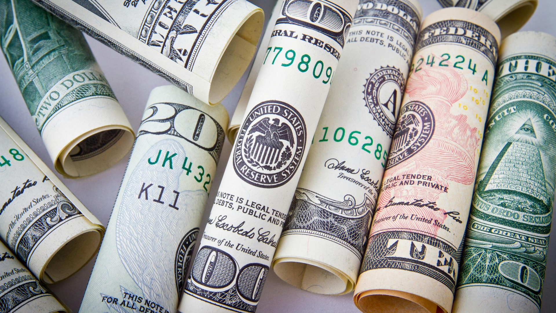 Rolled-up US dollar bills in various denominations, close-up shot.