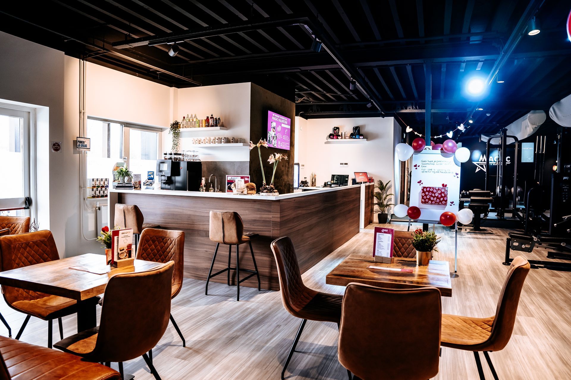 Een restaurant met tafels en stoelen en een bar.