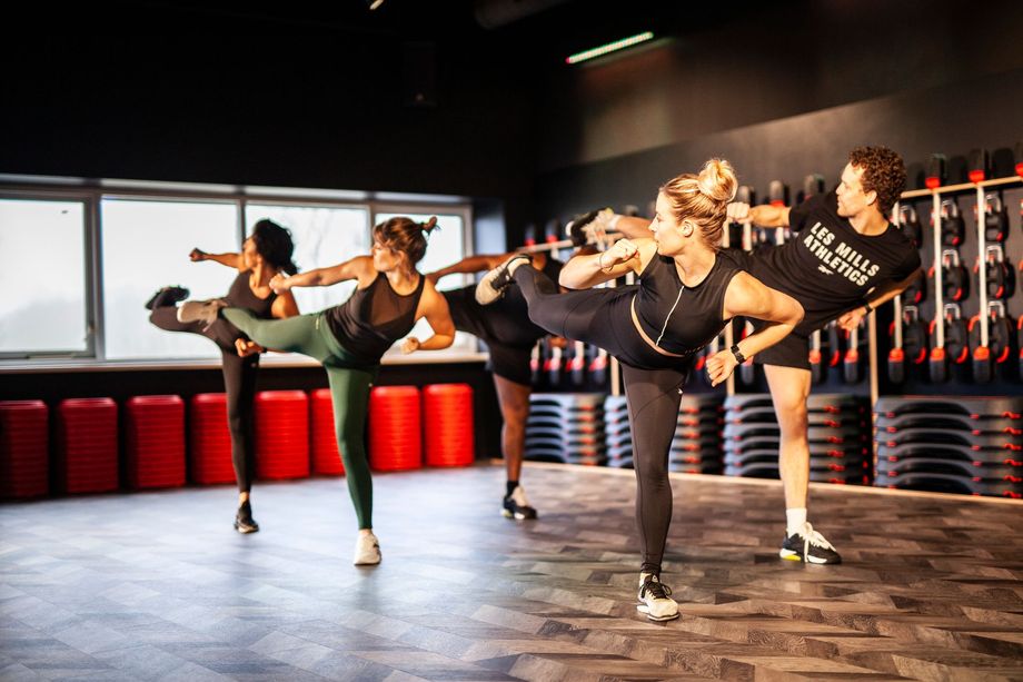 Een groep mensen doet oefeningen in een sportschool.