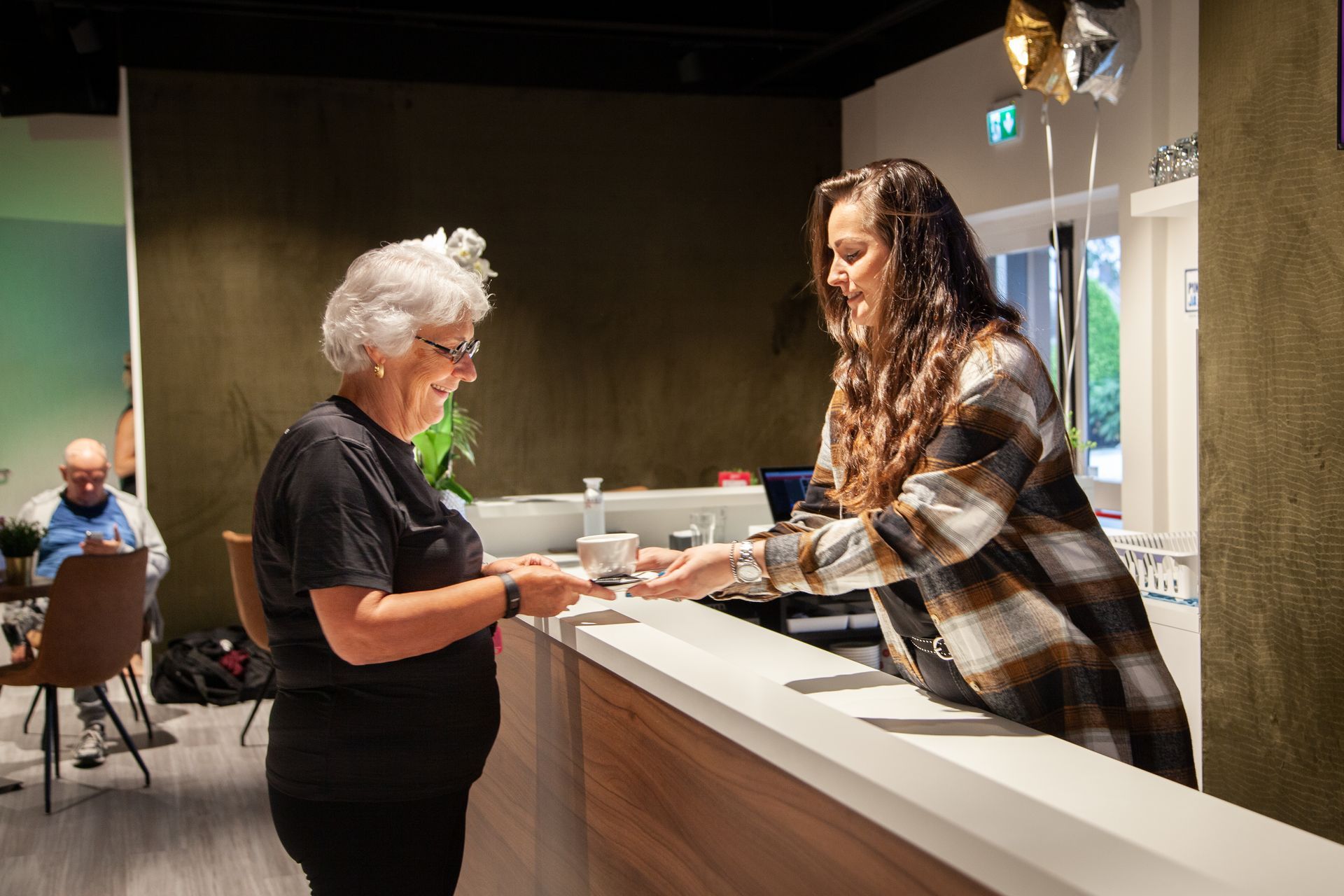 Twee vrouwen staan aan een toonbank in een restaurant.