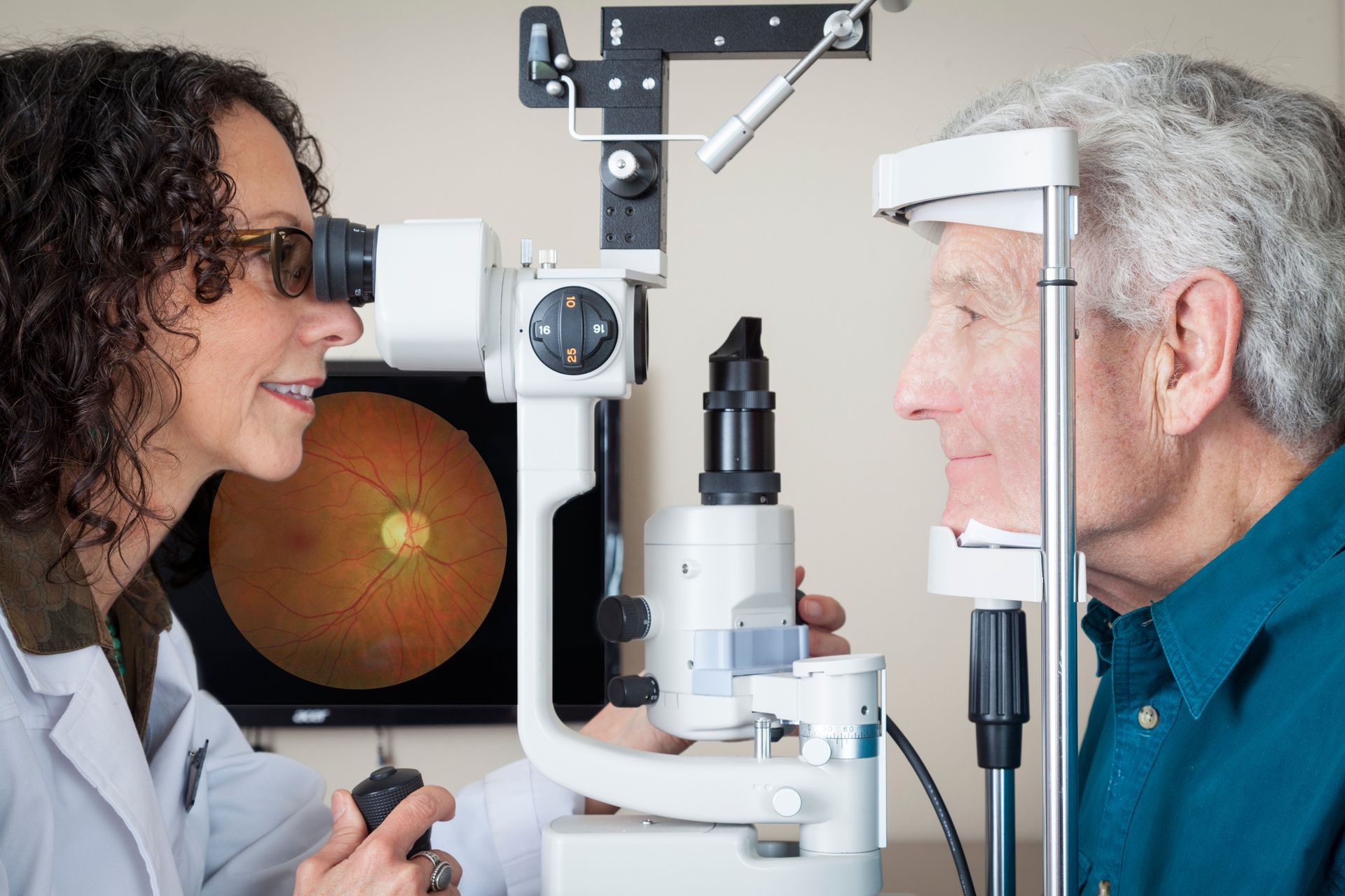 An optometrist performing an eye exam on a senior patient to detect macular degeneration.