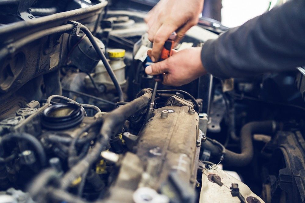 A Man is Working on the Engine of a Car — Pialba Brake Clutch & Steering Centre in Pialba, QLD