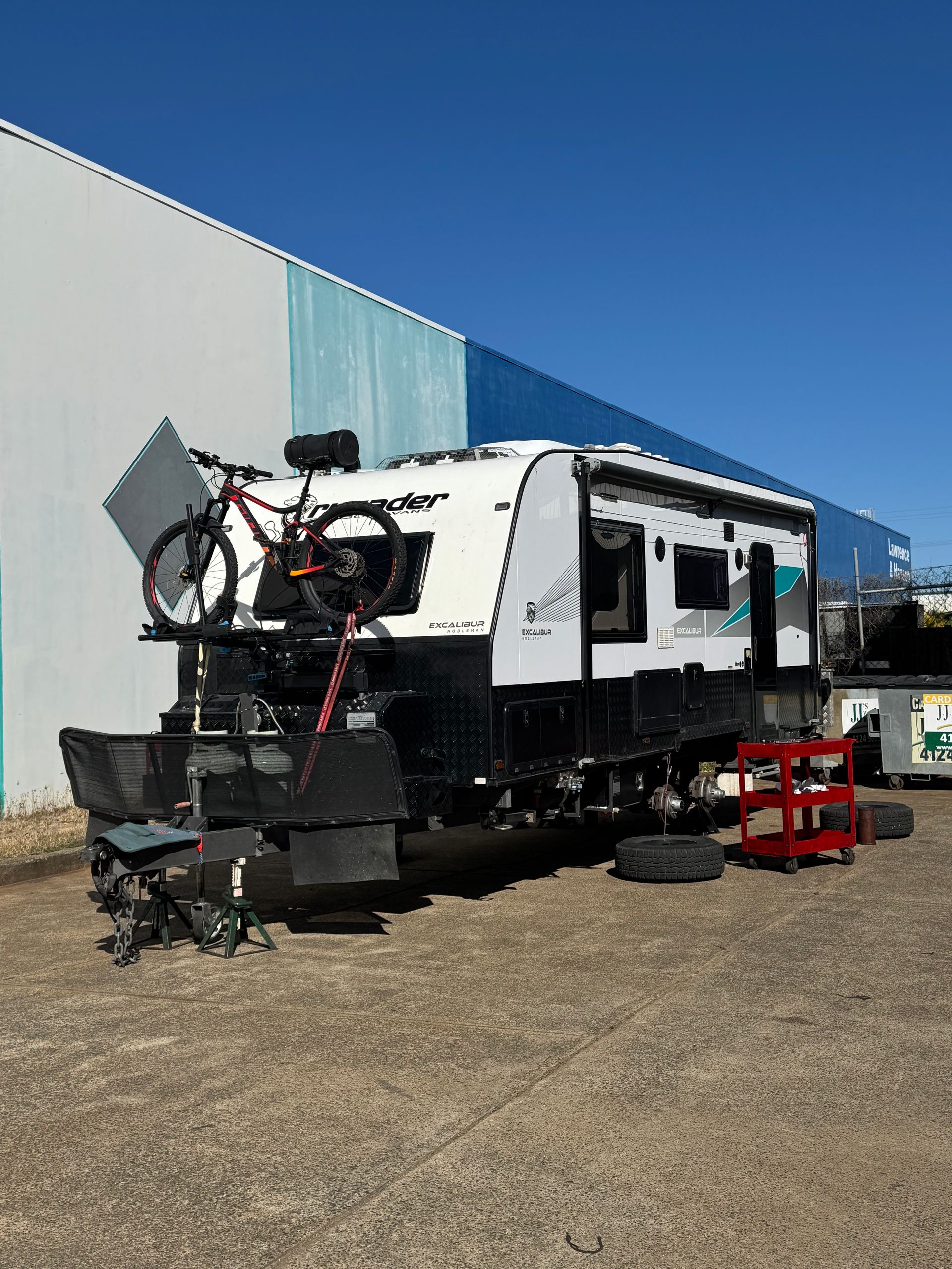 RV with bike on top, tracks instead of wheels, parked in front of a building on a sunny day — Pialba Brake Clutch & Steering Centre in Pialba, QLD