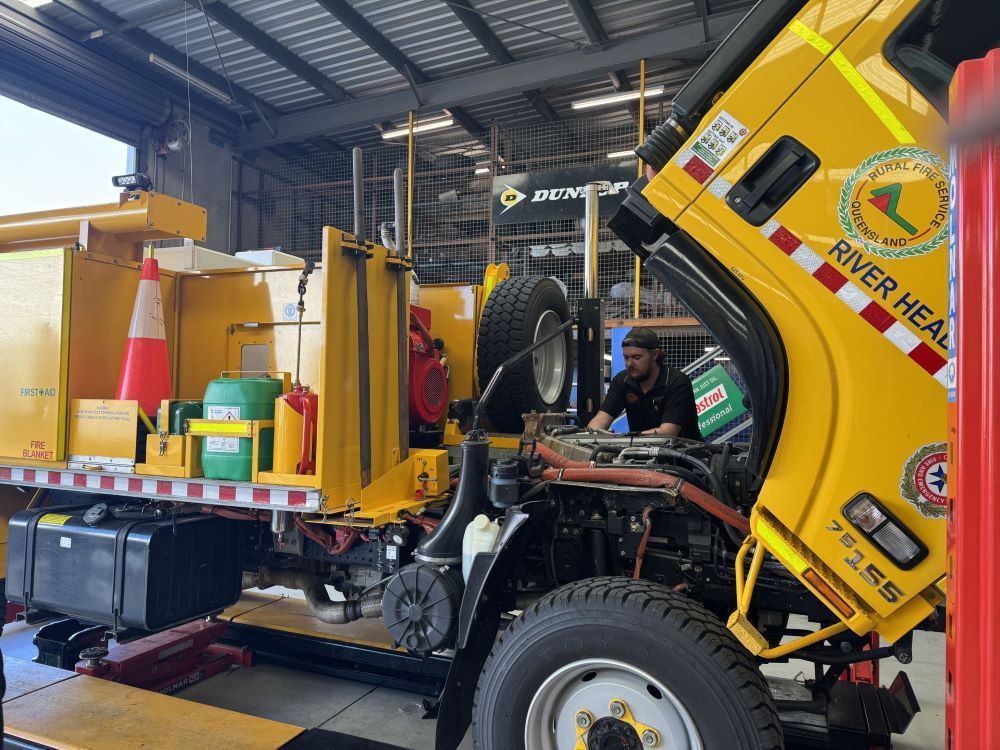 A Garage Scene with A Yellow Service Vehicle Being Repaired — Pialba Brake Clutch & Steering Centre in Pialba, QLD