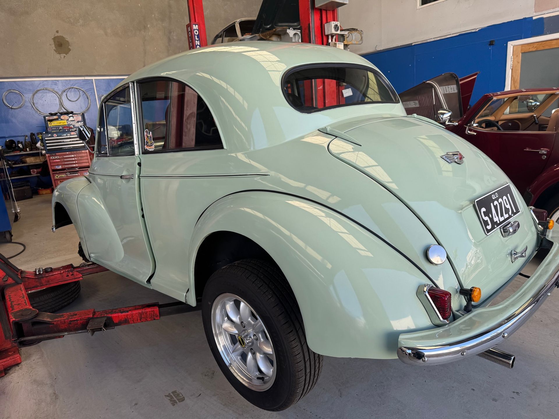 Light green classic car in a garage, partially raised on a lift — Pialba Brake Clutch & Steering Centre in Pialba, QLD