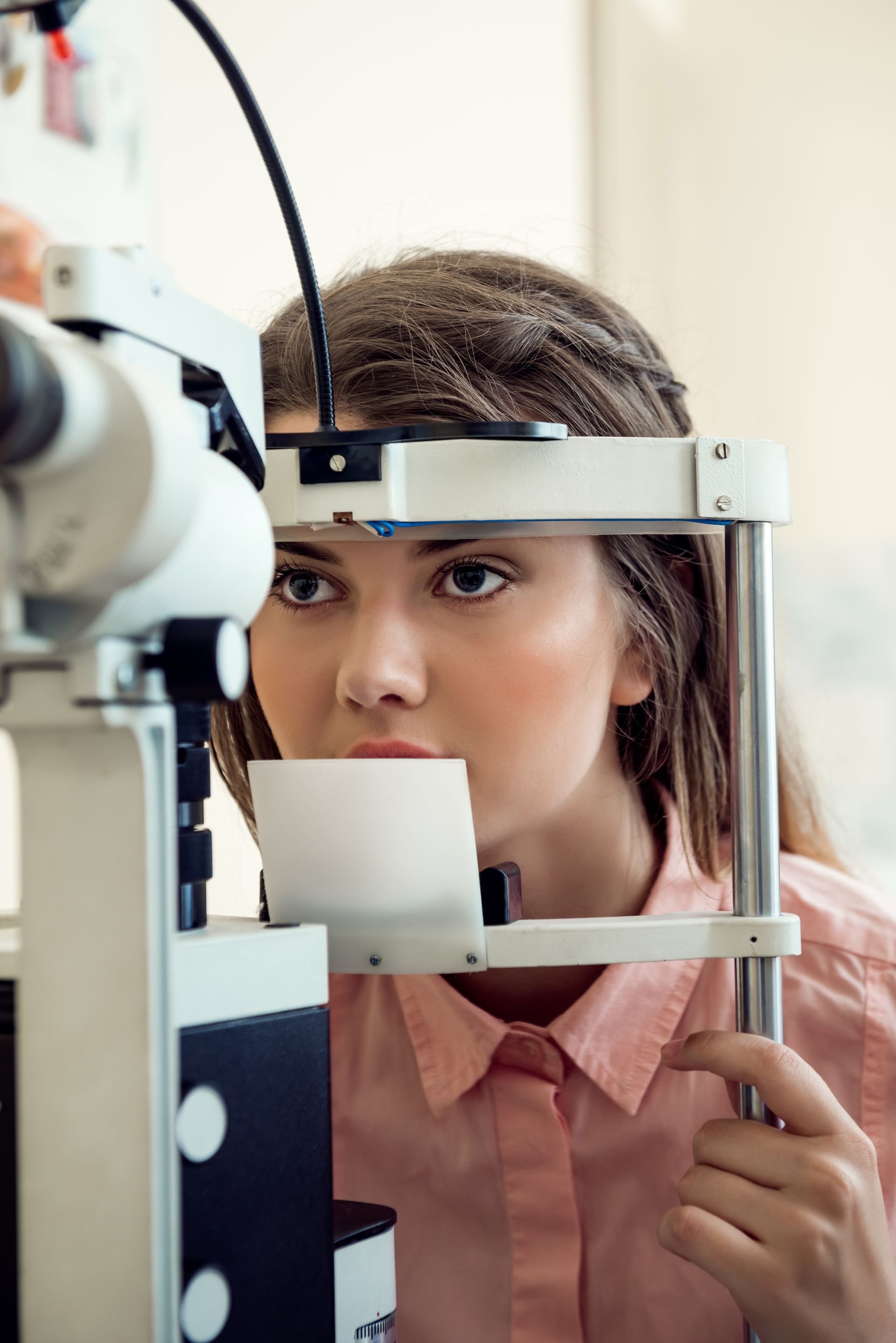 A person looking into a slit lamp biomicroscope during an eye examination.