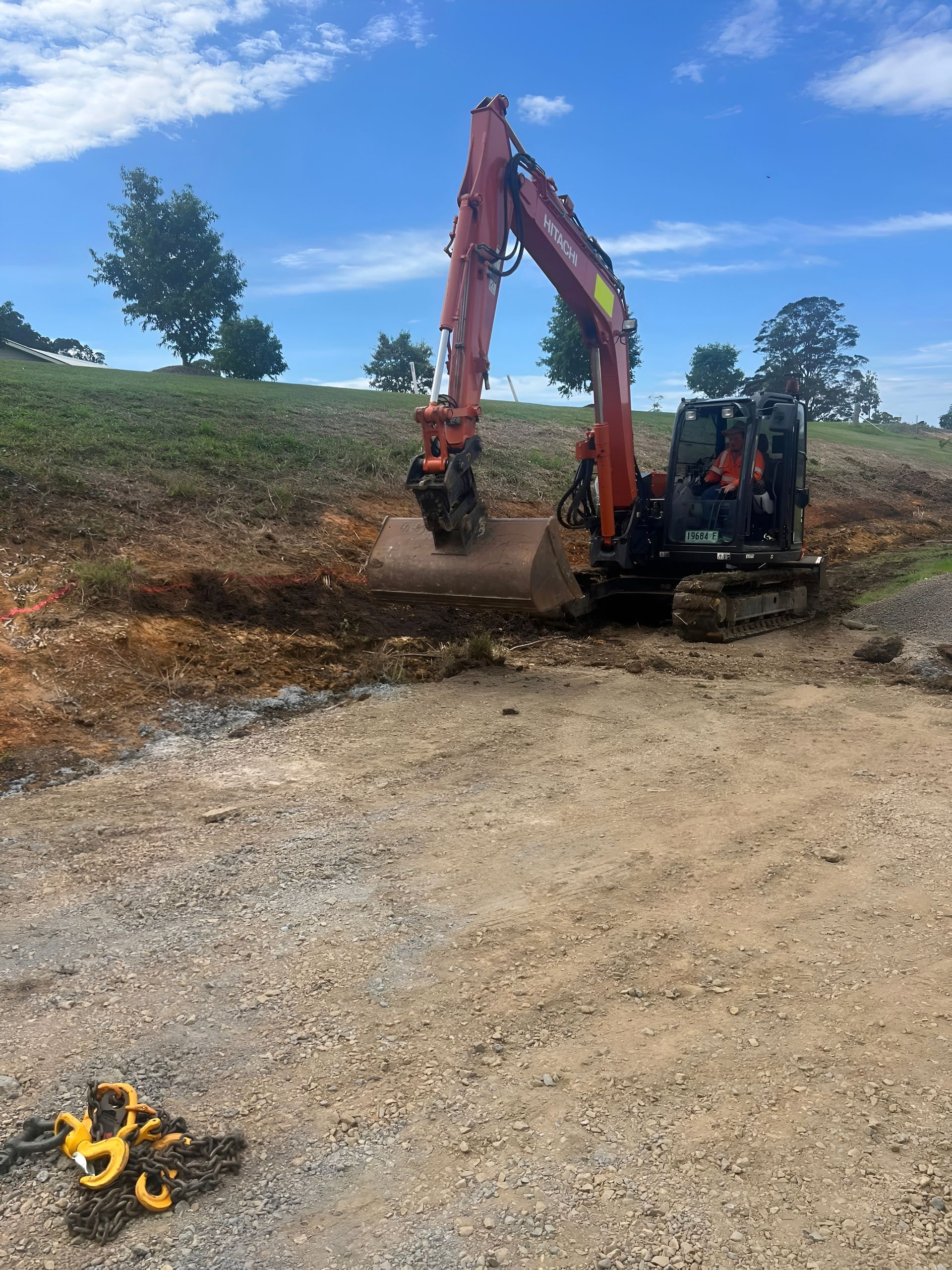Orange Excavator Digging Dirt on a Construction Site — MG Earthworks and Plant Hire in Gumma, NSW