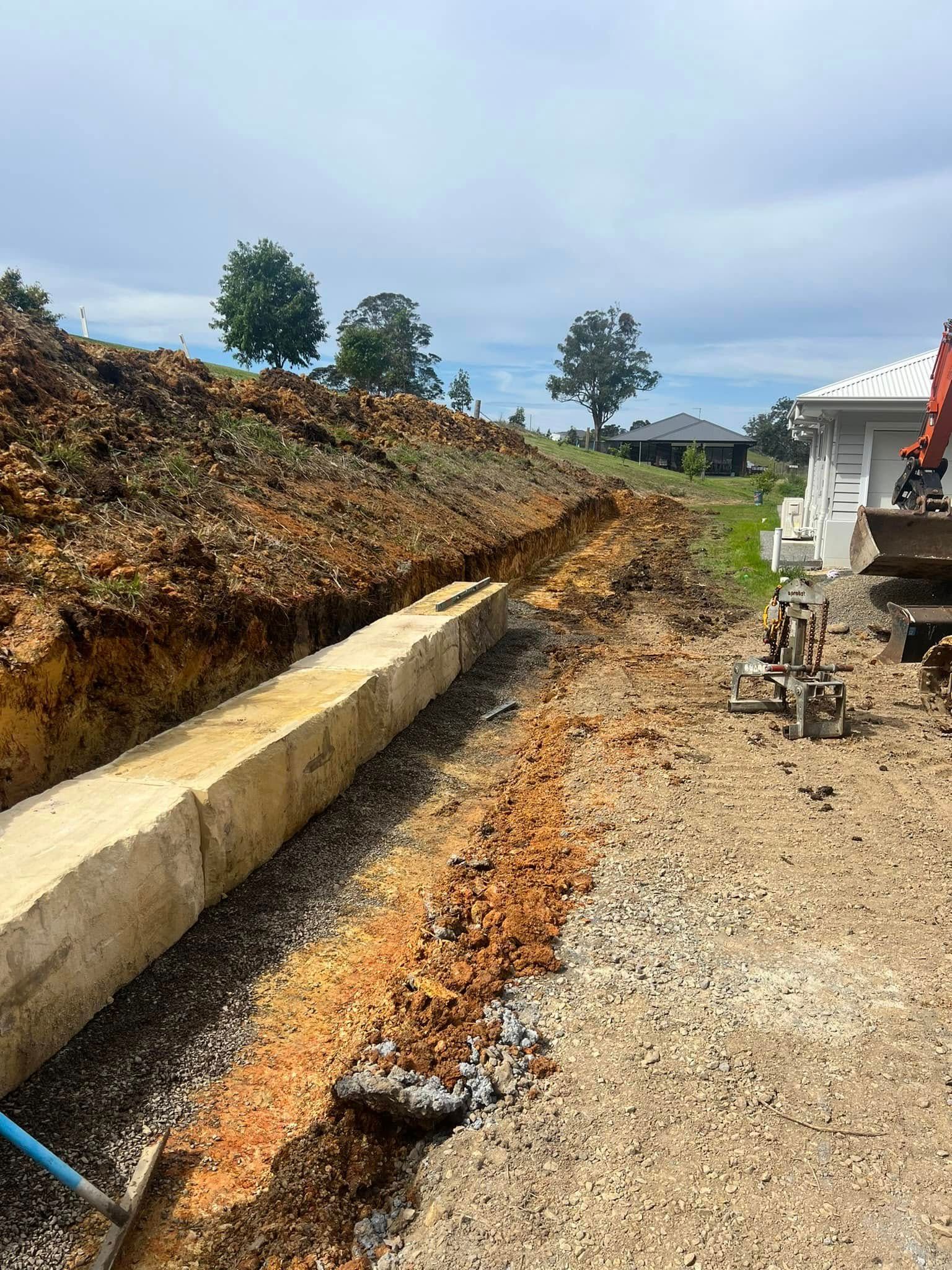 Trench With Retaining Blocks, Gravel, and Dirt — MG Earthworks and Plant Hire in Nambucca, NSW