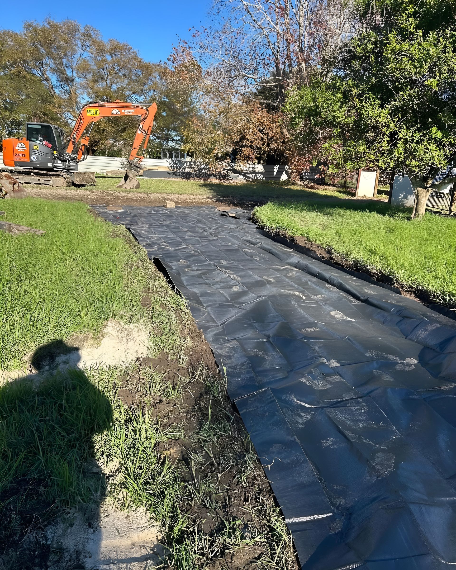 Black Landscape Fabric Laid in a Ditch in a Grassy Yard — MG Earthworks and Plant Hire in Gumma, NSW