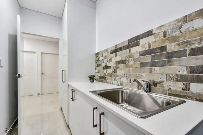 A Kitchen With A Sink And A Brick Wall — Tile Centre NT In Winnellie, NT