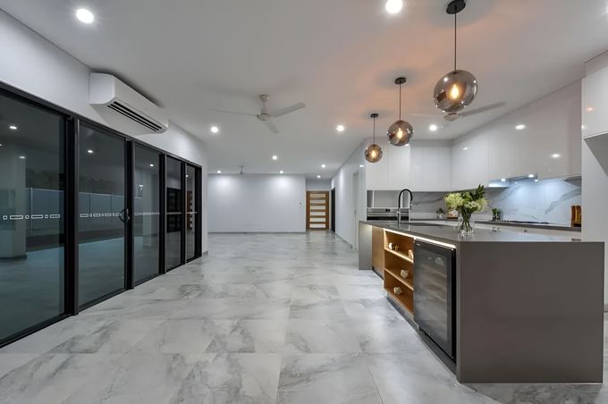 A Large Empty Room With A Kitchen And Sliding Glass Doors — Tile Centre NT In Winnellie, NT