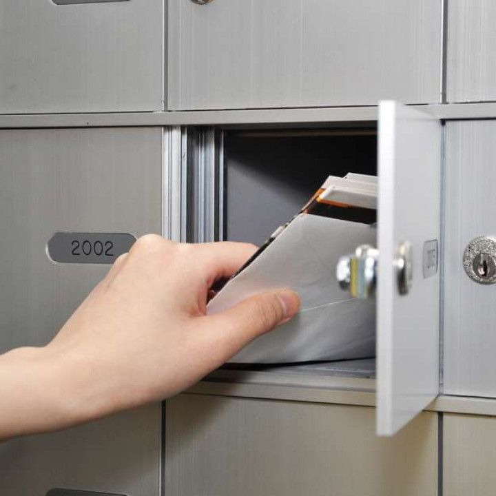 A Person Is Taking a Piece of Paper out Of a Mailbox.