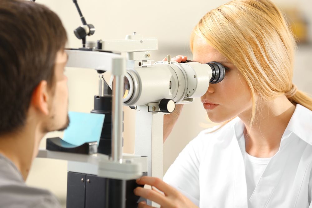 An Eye Doctor Examines a Patient’s Eye Using a Slit Lamp Microscope — Peninsula Eyecare Izzards Optometrists in Gosford, NSW