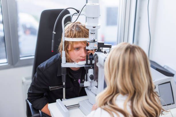 A Person Sits at an Eye Exam Machine — Peninsula Eyecare Izzards Optometrists in Kariong, NSW
