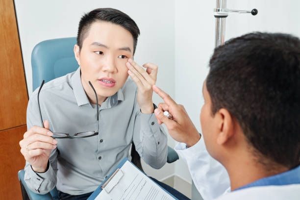 A Patient in a Doctor’s Office Points to Their Eye — Peninsula Eyecare Izzards Optometrists in Woy Woy, NSW