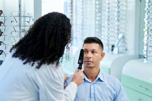 An Optometrist Uses an Ophthalmoscope to Examine a Patient's Eye — Peninsula Eyecare Izzards Optometrists in Woy Woy, NSW