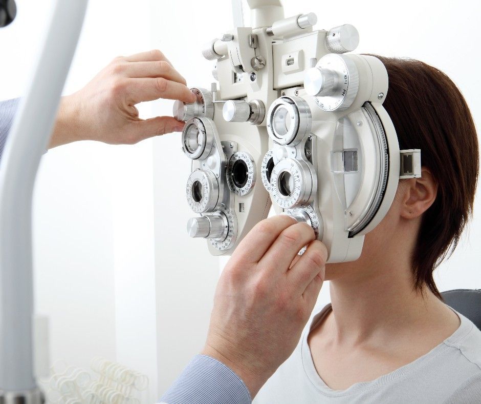 A Professional Performs an Eye Exam Using a Phoropter — Peninsula Eyecare Izzards Optometrists in Woy Woy, NSW