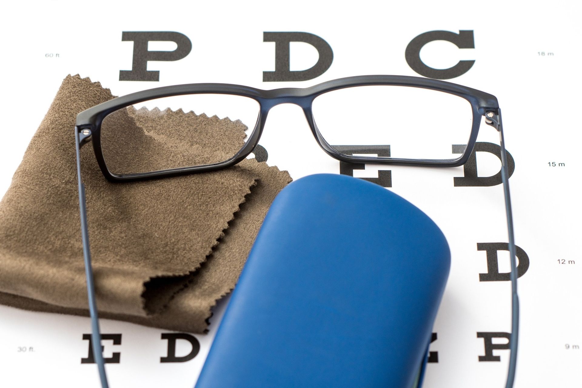 A Pair of Glasses, a Blue Hard Case, and a Cleaning Cloth — Peninsula Eyecare Izzards Optometrists in Woy Woy, NSW