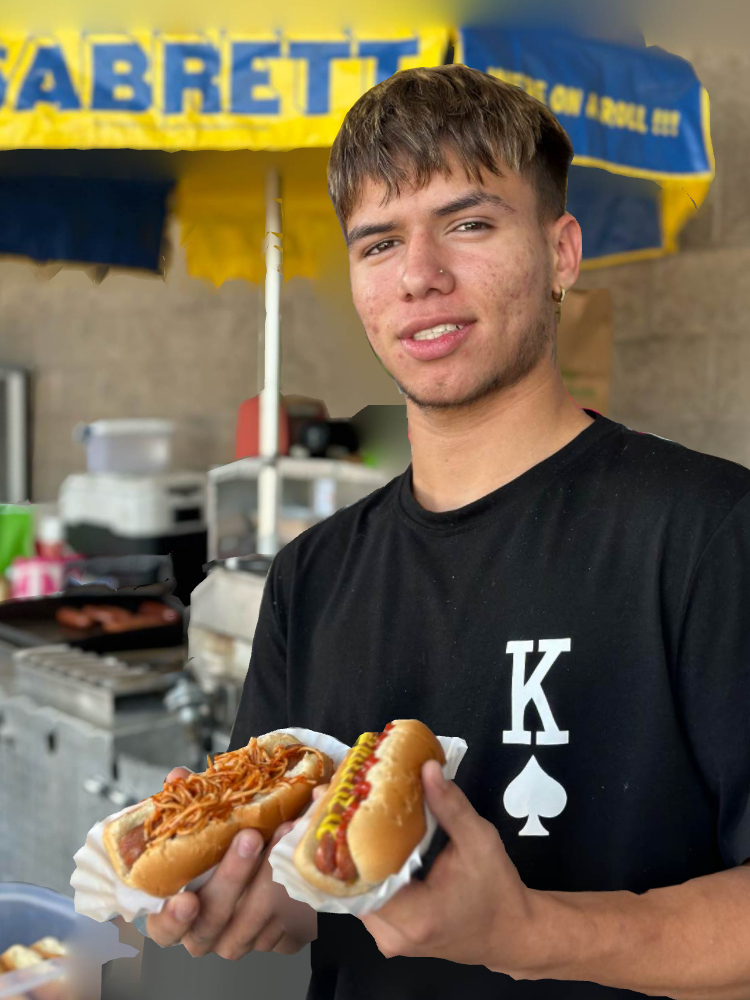 A Young Man Holding Hotdogs In A Bun — Orlando, FL — The Hot Dog Guy Catering