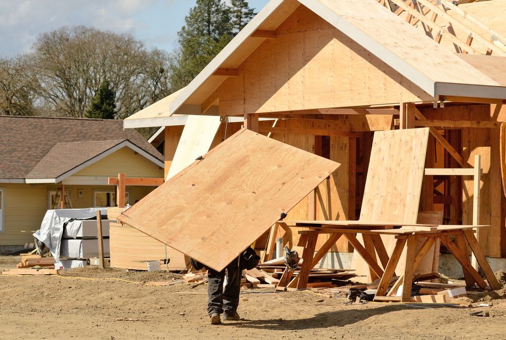 Construction Worker Carrying Plywood at a House — Wilko Plate (Aust) Pty Ltd in Atherton, QLD