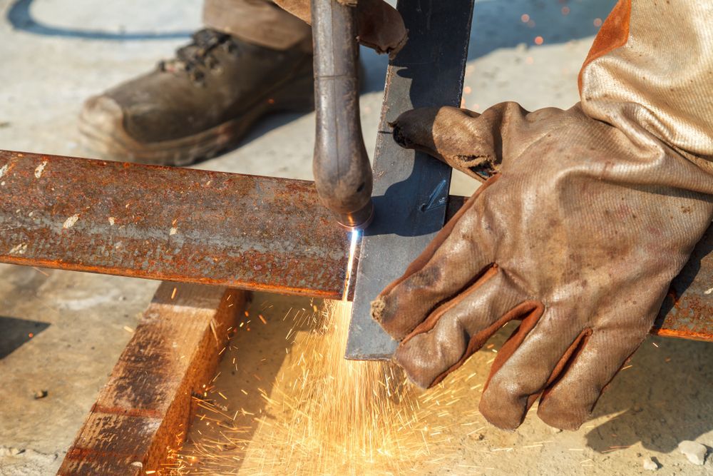 A Man Forging a Steel Plate with Gloves — Wilko Plate (Aust) Pty Ltd in Annandale, QLD