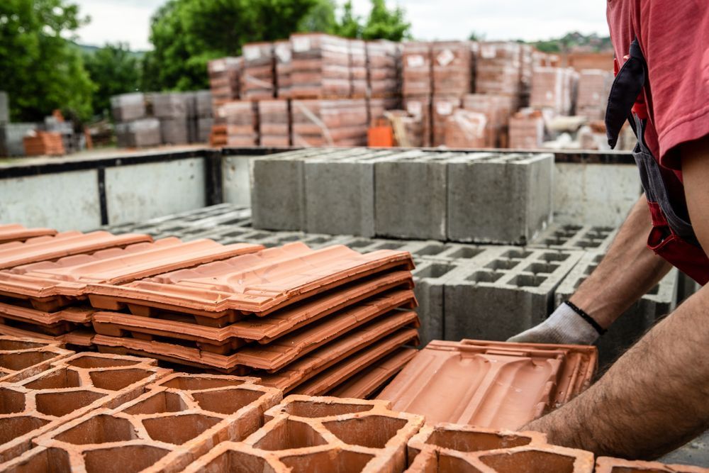 Man in Gloves Loading Construction Materials — Wilko Plate (Aust) Pty Ltd in Annandale, QLD
