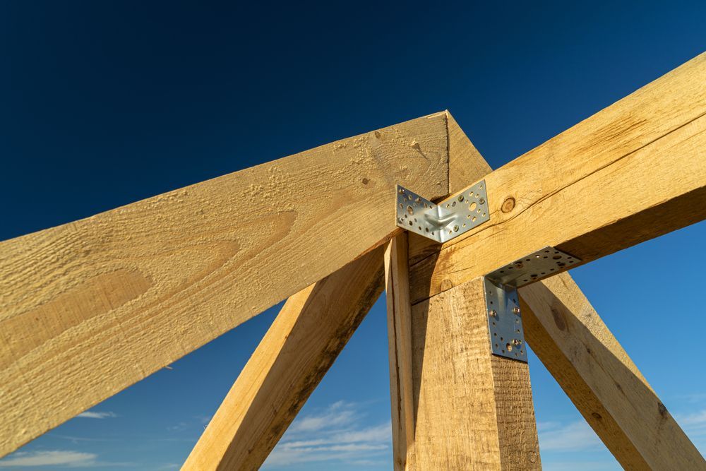 Wooden Roof Truss Corner With Metal Brackets Against a Blue Sky — Wilko Plate (Aust) Pty Ltd in Tully, QLD