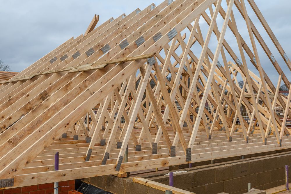 Wooden Roof Trusses Being Installed on a Building Under Construction — Wilko Plate (Aust) Pty Ltd in Innisfail, QLD
