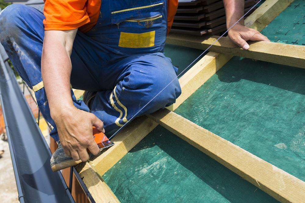 Roofer Wearing Blue Overalls and Orange Shirt — Wilko Plate (Aust) Pty Ltd in Atherton, QLD