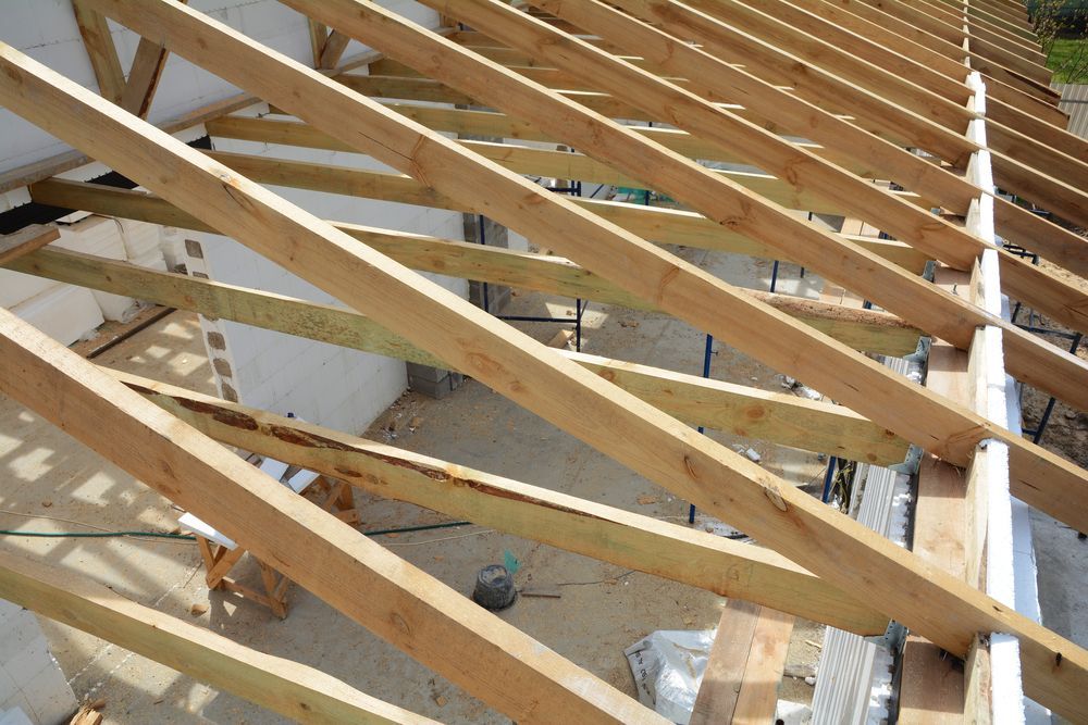 Wooden Roof Trusses Being Built on a Light-colored Building — Wilko Plate (Aust) Pty Ltd in Charters Towers, QLD
