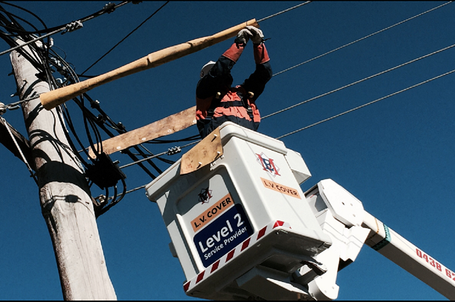 A Man is Working on a Power Line in a Level 2 Bucket — Gunter Electrical In Kariong, NSW