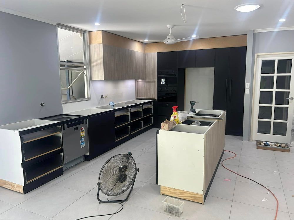 A Kitchen Under Construction With a Fan on the Floor — Designer Kitchens in Berrimah, NT