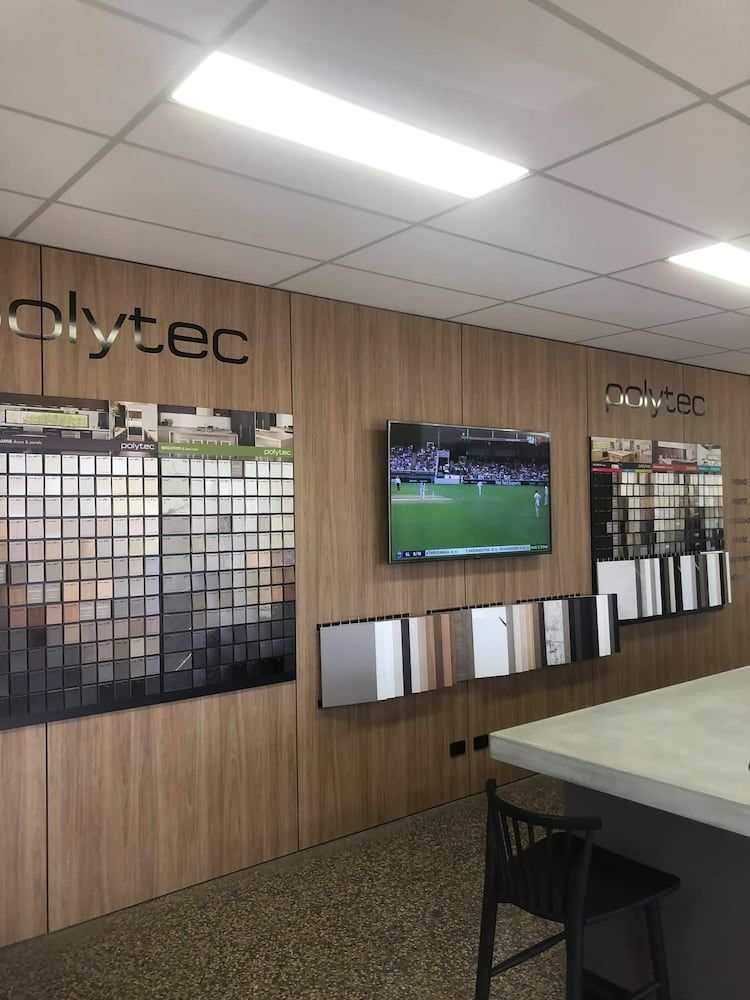 A Room With a Tv on the Wall That Says POLYTEC — Designer Kitchens in Berrimah, NT