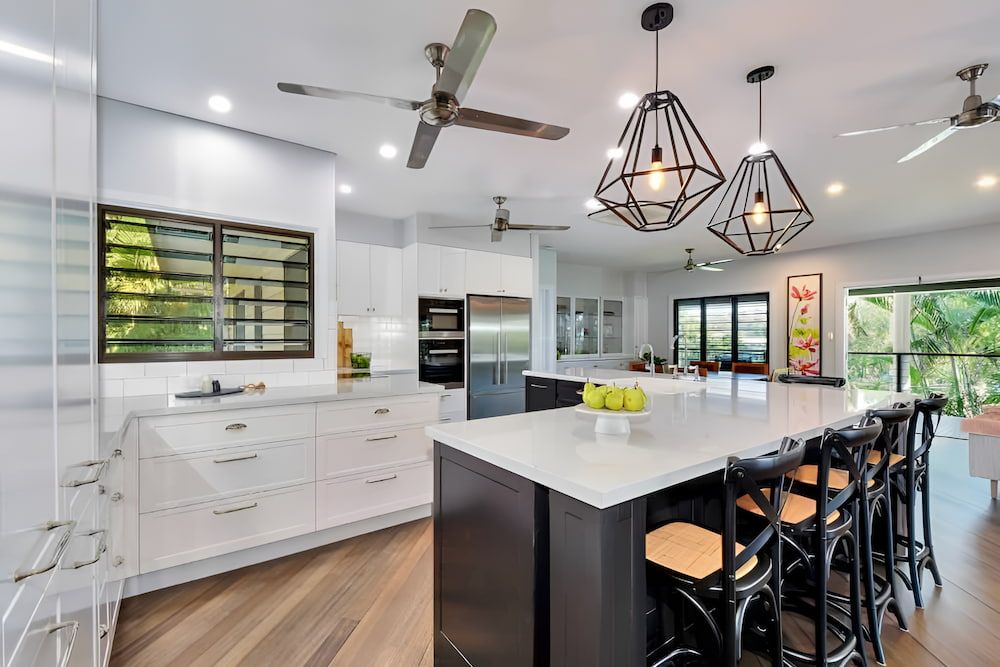A Kitchen With Stainless Steel Appliances and Wooden Cabinets — Designer Kitchens in Berrimah, NT