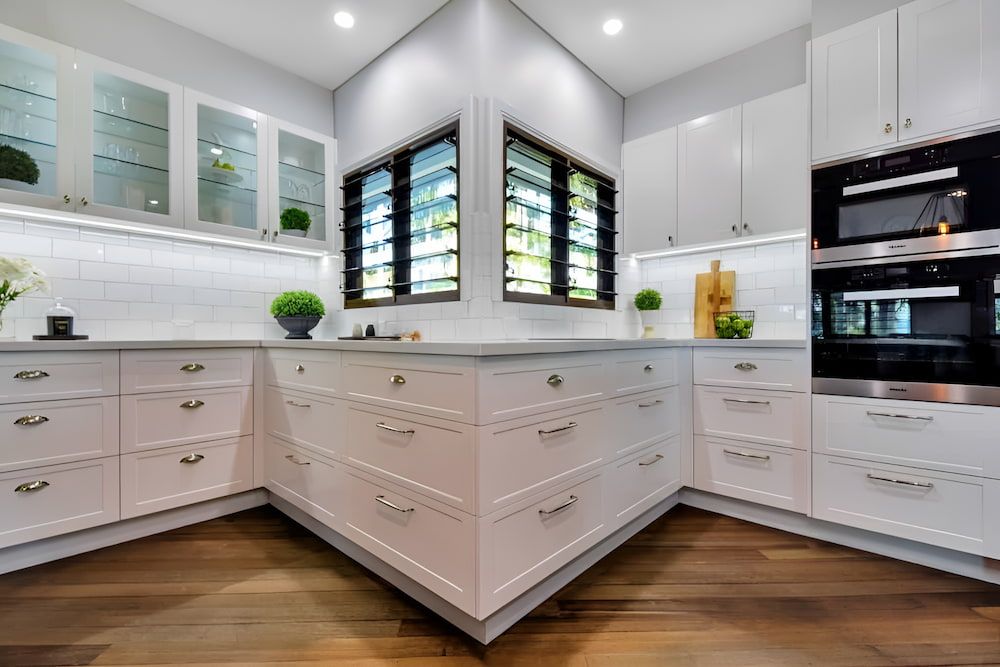 A Kitchen With Green Cabinets and a White Counter Top — Designer Kitchens in Berrimah, NT
