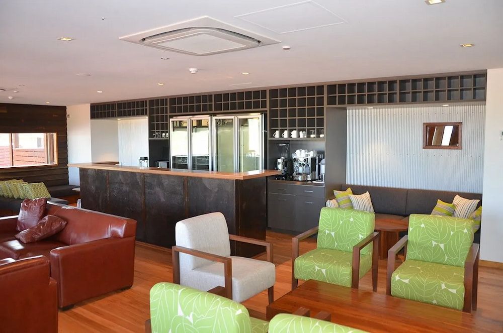 A Living Room With Green Chairs and a Red Couch — Designer Kitchens in Berrimah, NT