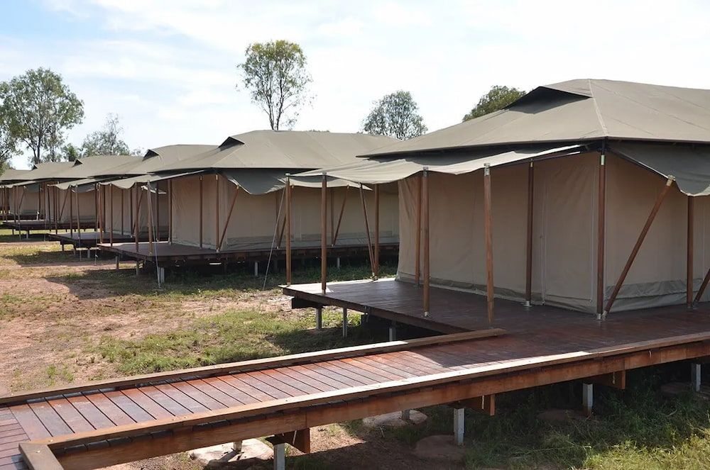 A Row of Tents With a Wooden Walkway Between Them — Designer Kitchens in Berrimah, NT