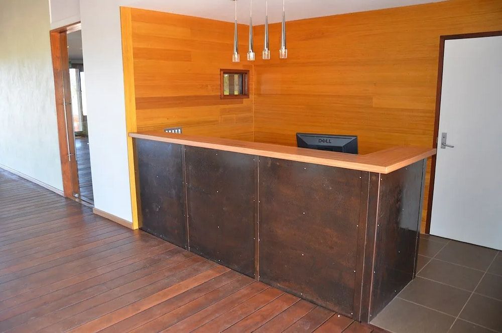 A Reception Desk in a Room With a Wooden Wall — Designer Kitchens in Berrimah, NT
