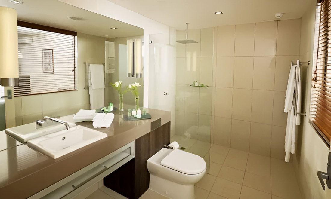 A Bathroom With a Toilet, Sink, Mirror and Walk in Shower — Designer Kitchens in Berrimah, NT