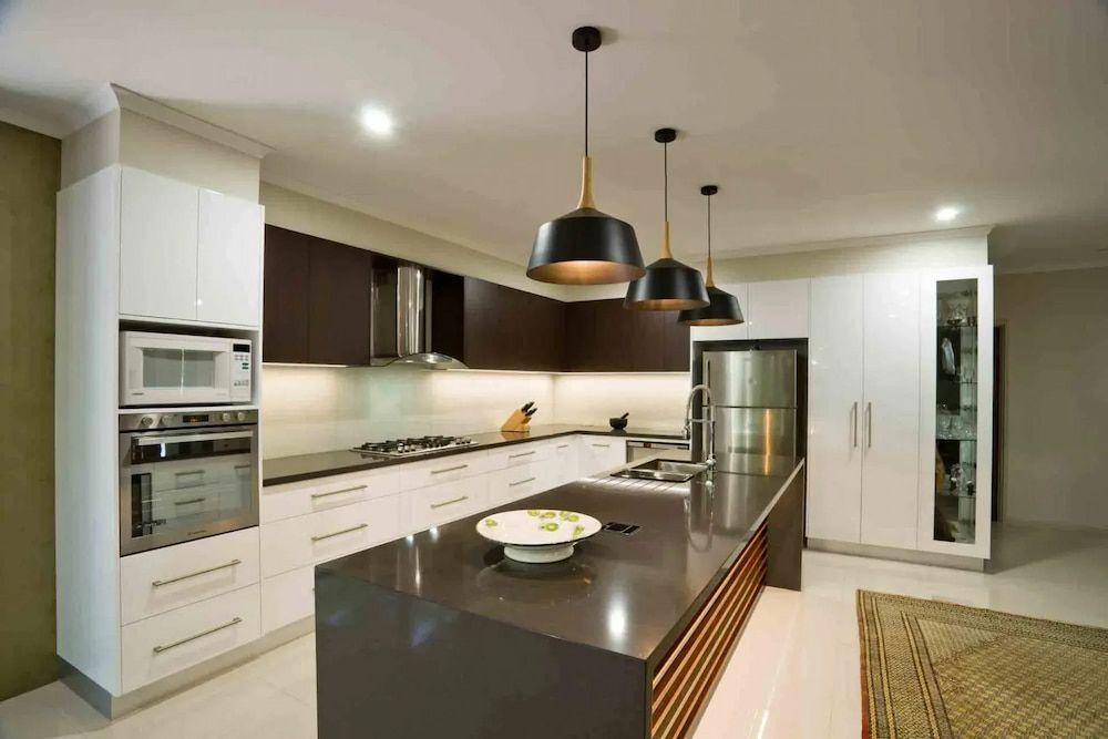 A Kitchen With White Cabinets and Stainless Steel Appliances — Designer Kitchens in Berrimah, NT
