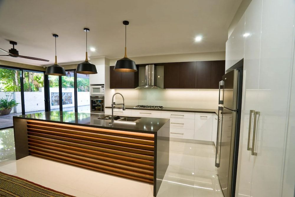 A kitchen with a large island and stainless steel appliances — Designer Kitchens in Berrimah, NT