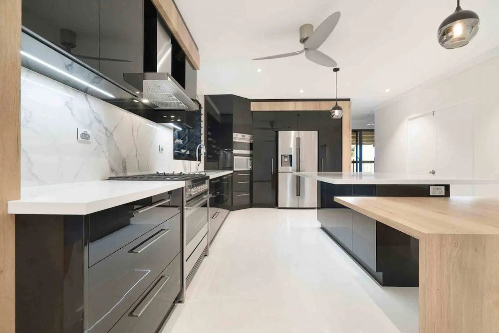 A Kitchen With Stainless Steel Appliances and a Ceiling Fan — Designer Kitchens in Berrimah, NT