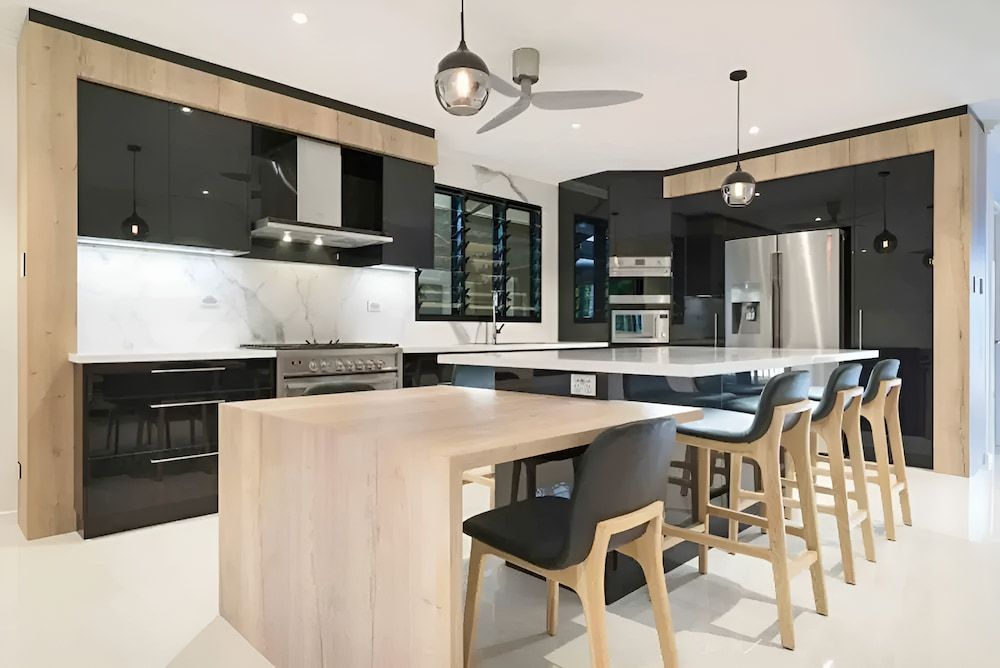 A kitchen with a table and chairs and a ceiling fan — Designer Kitchens in Berrimah, NT